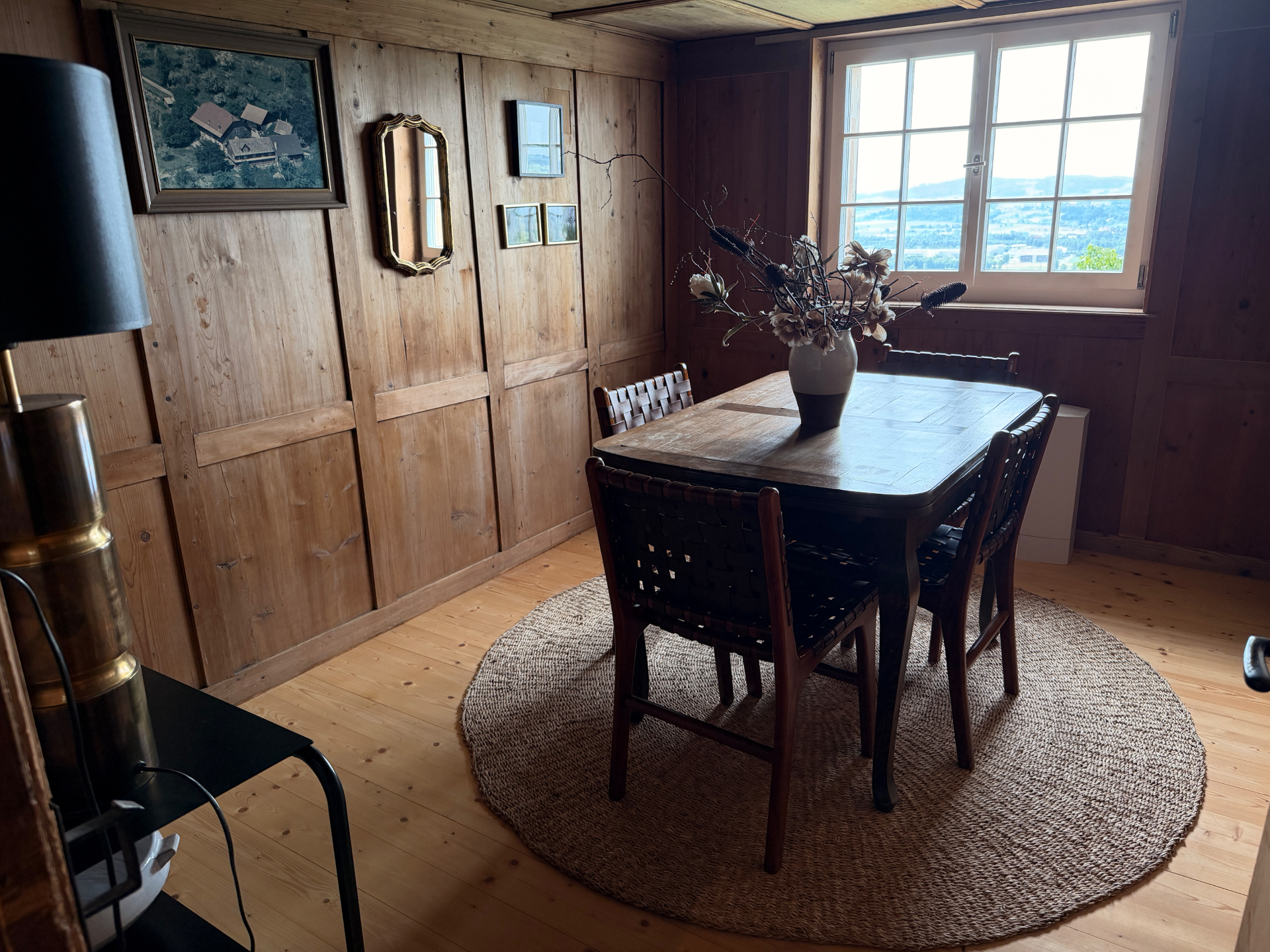 Alti Stube mit Esstisch, Holztäfer und Fenster mit Aussicht ins Thurtal